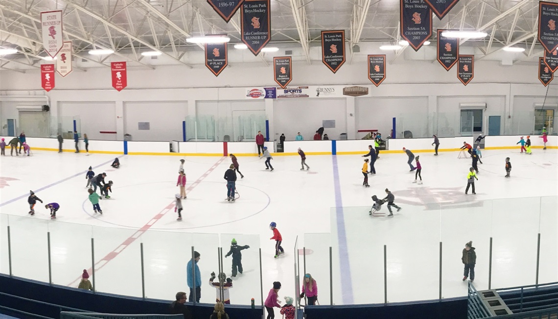 People skating at indoor ice arena